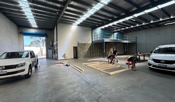 Prime Maintenance Projects team members working on a construction project inside a spacious, modern warehouse facility.